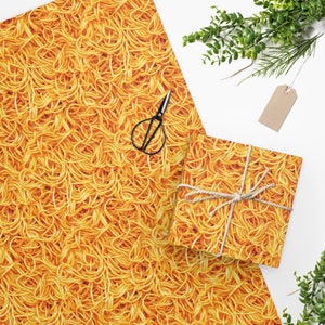 May include: A sheet of yellow and orange wrapping paper with a pattern of spaghetti noodles. A smaller sheet of the same wrapping paper is wrapped around a gift box with twine.