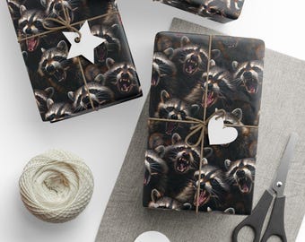 Könnte beinhalten: Geschenkpapier mit einem sich wiederholenden Muster von wütenden Waschbären auf dunklem Hintergrund. Die verpackten Geschenke sind mit Bindfaden gebunden und mit weißen stern- und herzförmigen Anhängern verziert. Ein Knäuel Bindfaden, eine Schere und leere Anhänger sind ebenfalls vorhanden.