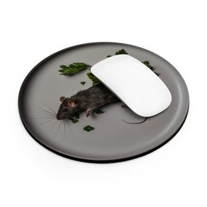 May include: A gray mouse pad with a black border features a dead mouse and a white computer mouse on top of it. The mouse is surrounded by green parsley.