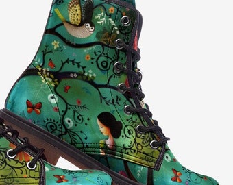 May include: A pair of teal combat boots with a whimsical forest scene. The boots feature a detailed illustration of a woman, birds, butterflies, and floral elements. Black laces and a brown sole complete the design.