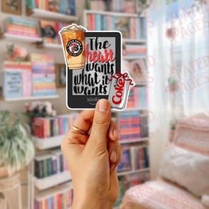 May include: A sticker featuring a Kindle, a 7-Eleven iced coffee, and a Diet Coke can. The Kindle has the text "The heart wants what it wants." The coffee cup has the 7-Eleven logo. The Diet Coke can has the Diet Coke logo.