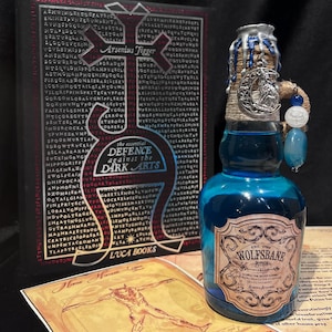 May include: A blue glass bottle with a silver label that reads "Wolfsbane Potion" and a silver cap with a wolf's head design. The bottle is sitting on a table with a book and a piece of paper with a drawing of a werewolf.