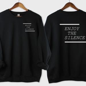 May include: Black sweatshirt with the text "Enjoy the Silence" printed on the front and back in white.