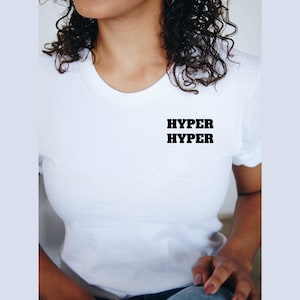 May include: White t-shirt with the word "HYPER" printed three times in black.