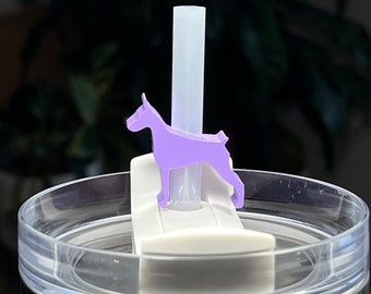 May include: A purple dog-shaped straw topper for a tumbler. The topper is made of plastic and has a hole in the center for a straw to go through.