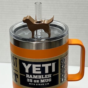 May include: Orange YETI Rambler 35 oz mug with a straw lid and a brown dog-shaped lid topper.