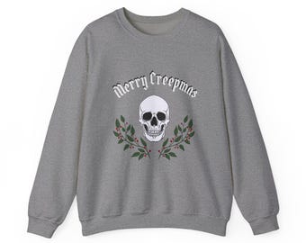 May include: A gray sweatshirt with a white skull and the text "Merry Creepmas" in a gothic font. The skull is surrounded by green leaves and red berries.