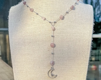 Puede incluir: Un collar de cadena de plata con cuentas de piedras preciosas rosas y un dije de luna creciente.