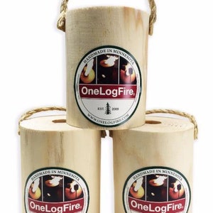 May include: Three wooden logs with a rope handle. Each log has a green and red circular label with the text "HANDMADE IN MINNESOTA" and "OneLogFire" with a small tree graphic and the text "EST. 2009" and "WWW.ONELOGFIRE.COM".