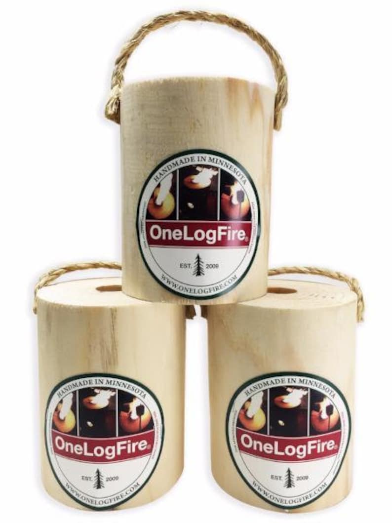 May include: Three wooden logs with a rope handle. Each log has a green and red circular label with the text "HANDMADE IN MINNESOTA" and "OneLogFire" with a small tree graphic and the text "EST. 2009" and "WWW.ONELOGFIRE.COM".