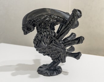 May include: A black 3D printed figurine of an alien creature with multiple arms and a detailed, textured surface.