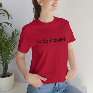 Op de afbeelding: Een rood T-shirt met de tekst "code-blooded" in zwart op de voorkant.