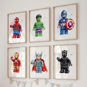 Peut inclure: Six cadres muraux présentant des illustrations à l'aquarelle de figurines de super-héros inspirées de Lego, dont Spider-Man, Hulk, Captain America, Iron Man, Thor et Black Panther, chacun dans un cadre en bois clair sur un mur blanc.