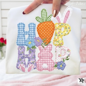 Op de afbeelding: Witte stof met het woord "HIP HOP" in kleurrijke applicatieletters. De "H" is blauw geruit, de "I" is een wortel, de "P" is geel bloemig, de tweede "H" is paars bloemig, de "O" is een konijn en de tweede "P" is bloemig.