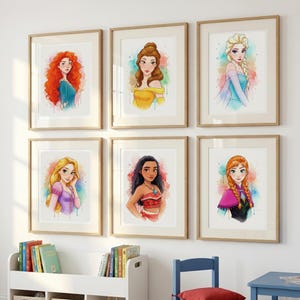 May include: Six framed watercolor prints of Disney princesses. Each portrait features a different princess with vibrant colors and a watercolor effect. The frames are a light wood color, and the artwork is displayed on a white wall.