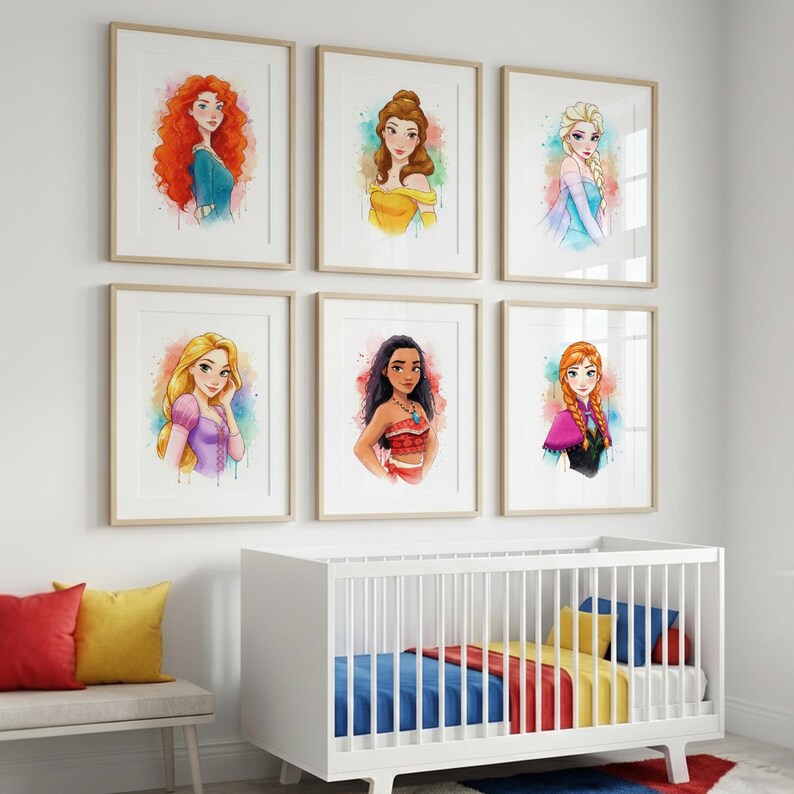 May include: Six framed watercolor prints of Disney princesses, including Merida, Belle, Elsa, Rapunzel, Moana, and Anna. Each portrait features vibrant colors and is set against a white background. The prints are displayed above a white crib and a bench with colorful pillows.