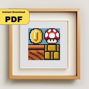 May include: Framed cross-stitch art featuring pixelated images of a gold coin, a red and white mushroom, and gold blocks. The artwork is in a wooden frame with the text "Instant Download PDF" in a yellow box.