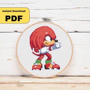 May include: A cross-stitch pattern of Knuckles the Echidna from the Sonic the Hedgehog video game series. The character is depicted in a fighting stance, with red fur, white gloves, and red shoes. The text "Instant Download PDF" is in a yellow box.
