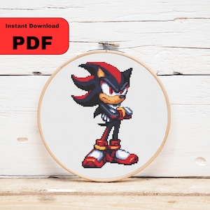 Może przedstawiać: Wzór haftu krzyżykowego przedstawiający Shadow the Hedgehog, postać z serii Sonic. Postać jest przedstawiona z czarnymi i czerwonymi kolcami, czerwonymi oczami i zdecydowanym wyrazem twarzy. Tekst "Instant Download PDF" znajduje się w czerwonym prostokącie.