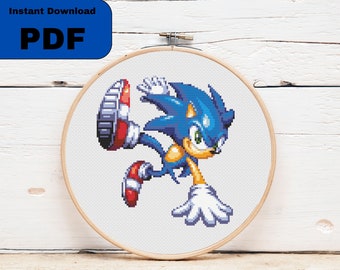 May include: Cross stitch pattern of Sonic the Hedgehog in a blue and yellow color scheme, running with his arms outstretched. The pattern is displayed in a wooden embroidery hoop.