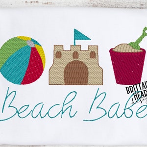 May include: Embroidered design of a beach ball, sandcastle, and bucket and shovel. The text "Beach Babe" is embroidered below the design.