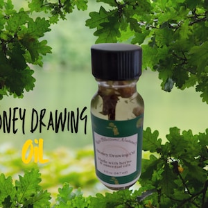 May include: A small, clear glass bottle with a black lid and a green label. The label says "Money Drawing Oil" and "Made with herbs & essential oils".