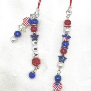 Patriotatic phone charms. glass beads, with clay flag spacer beads. 4 styles to choose from. Charm has the string loop to attach to phone.