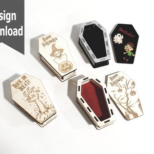 Puede incluir: Cinco cajas de madera con forma de ataúd con diferentes diseños de temática de Halloween. Los diseños incluyen un fantasma, una mano de zombi, un fantasma con el texto "BoCoCo!" y un árbol con calabazas y murciélagos. Una caja es negra con un interior negro.