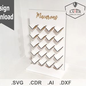 Könnte beinhalten: Ein weißer Macaron-Ständer aus Holz mit der Aufschrift "Macarons" in goldenen Buchstaben. Der Ständer hat 24 Fächer für Macarons.