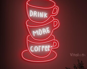 May include: Red neon sign with three stacked coffee cups that read "Drink More Coffee".