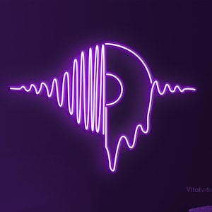 May include: A purple neon sign in the shape of a vinyl record with a sound wave design. The sign is mounted on a dark purple wall. The room has a sofa, a table, a candle, and a book.
