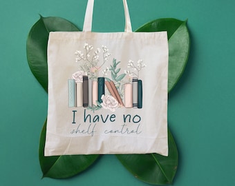 May include: A white canvas tote bag with a floral design and the text "I have no shelf control". The bag has a brown handle and is decorated with a stack of books and flowers.
