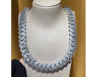 May include: A silver chain necklace with baguette-cut diamonds. The chain is a thick, chunky style.