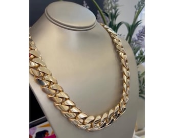 Peut inclure: Un collier chaîne en or épais avec un design à maillons plats. La chaîne est présentée sur un buste de mannequin.