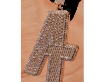 May include: A gold pendant shaped like the letter A, completely covered in small, clear diamonds.