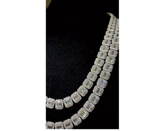 May include: A silver necklace with a double row of large, square-shaped, clear cubic zirconia stones.