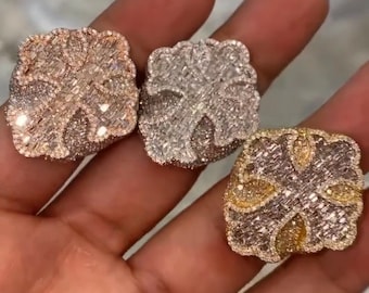 May include: Three gold rings with a diamond-like design. The rings are set with small, clear stones and have a four-leaf clover shape.