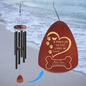 May include: A red wooden wind chime with a heart-shaped design and the text "A piece of my heart lives in heaven". The chime is decorated with paw prints and a butterfly. The bottom of the chime has a bone-shaped design with the text "Name Here D.O.B. D.O.D."