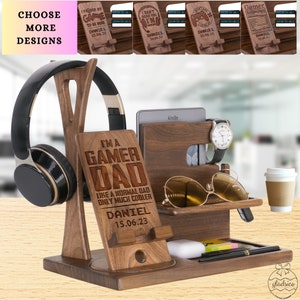 May include: A wooden organizer with a phone stand, watch holder, sunglasses holder, and a cup holder. The organizer has a personalized plaque that reads "I'm a Gamer Dad Like a Normal Dad Only Much Cooler Daniel 15.06.23".