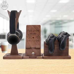 May include: A wooden desk organizer set featuring a headphone stand, a phone stand with the text "I wish you lived next door", and a game controller stand. The set is made of dark brown wood.