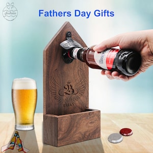 May include: Wooden bottle opener with a built-in bottle cap catcher. The opener is engraved with a crown, the number 23, and the name "BRIAN". A hand is shown opening a bottle of beer with the opener.