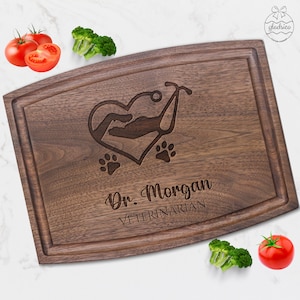 May include: A brown wooden cutting board with a heart, stethoscope, paw prints, and the text "Dr. Morgan VETERINARIAN" engraved on it.