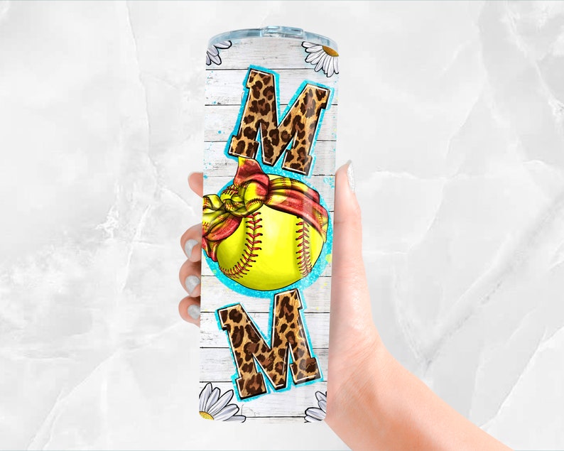 K&ouml;nnte beinhalten: Ein wei&szlig;er Becher mit Holzmaserung und einem Softball mit rotem Bandana. Das Wort "MOM" ist in Leopardenmuster auf dem Becher geschrieben.