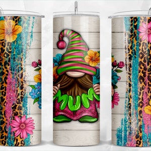 May include: A stainless steel tumbler with a colorful design. The design features a gnome holding the word "MUM" surrounded by flowers. The tumbler also has a leopard print and floral accents in pink, blue, and yellow.