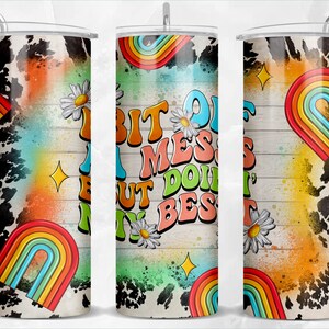 Könnte beinhalten: Ein Edelstahlbecher mit einem weißen und schwarzen Kuhfellmuster im Hintergrund. Der Becher hat ein Regenbogen-Design und den Text "A Bit Of A Mess But I Do It My Best".
