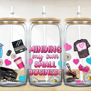 May include: Three clear glass jars with wooden lids and straws. Each jar has a different design with pink, blue and white accents. The middle jar has the text "MINDING my own SMALL BUSINESS".