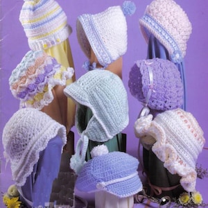 May include: A collection of nine handmade crochet baby hats in various colors and styles. The hats include bonnets, beanies, and sun hats, with details like pom-poms, ribbons, and scalloped edges. Colors include white, blue, yellow, and lavender.