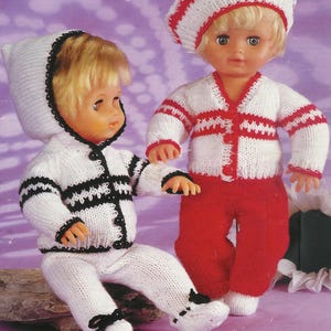 May include: Two dolls dressed in knitted outfits. One doll is seated in a white hooded jacket and trousers with black trim. The other doll wears a white cardigan with red stripes, a matching beret, and red trousers.