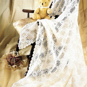 May include: White crocheted baby blanket with a delicate floral pattern, draped over a wooden chair with a teddy bear sitting on it.