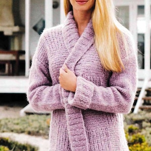 Peut inclure: Un cardigan en tricot doux de couleur lilas clair avec un col châle et une ceinture à nouer. Le cardigan est fait d'un fil moelleux et a une coupe ample.